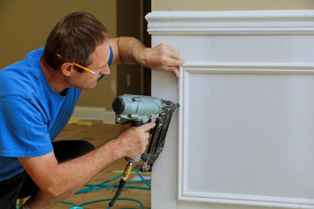 Moulding and millwork technician adding wall highlights to the bottom portion of a wall
