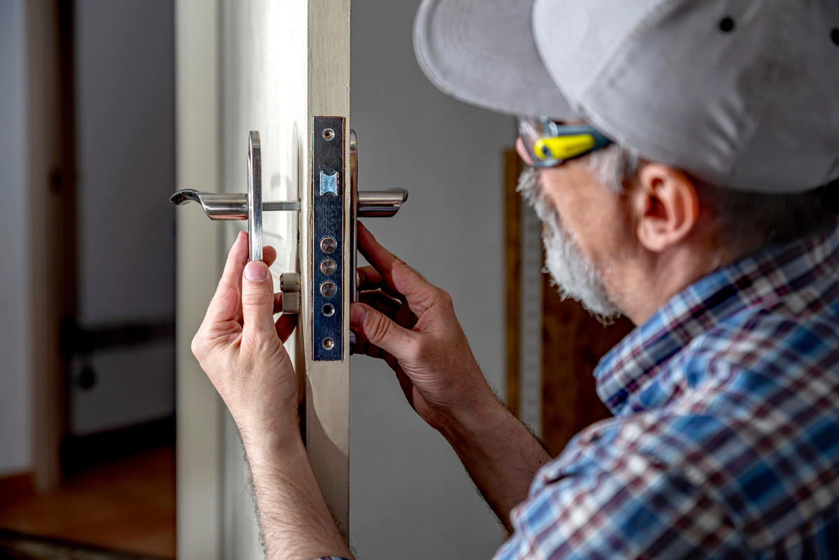 A man installing new door hardware in an El Paso home.